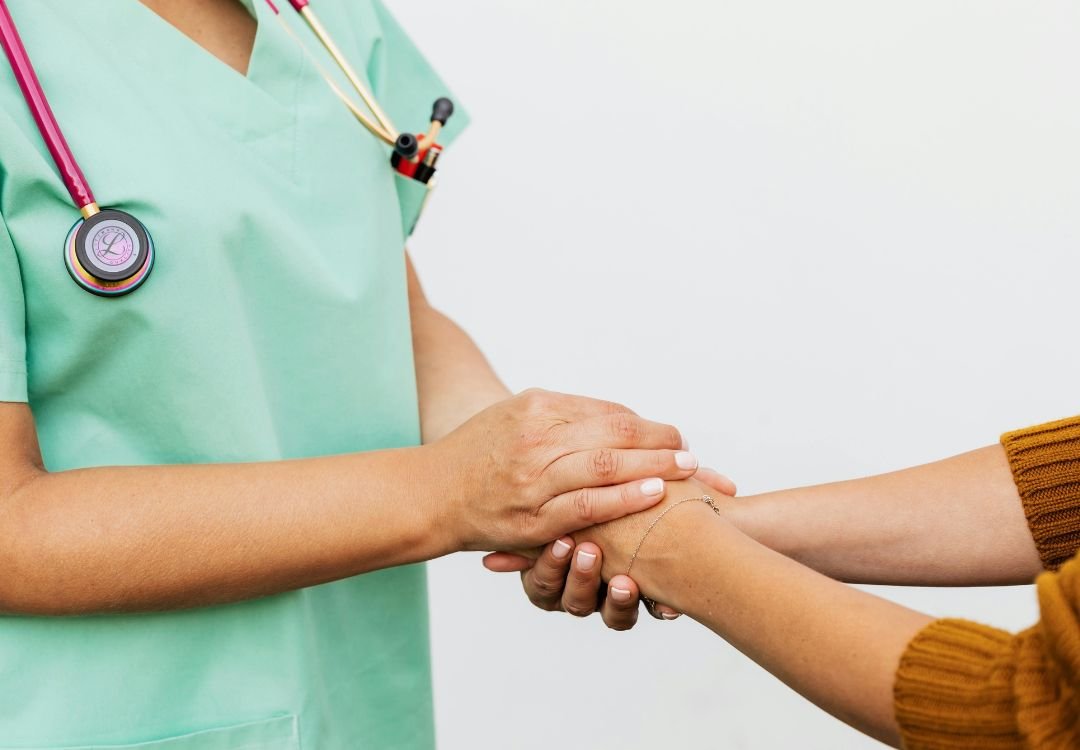 Clinician holding a patient's hands with care